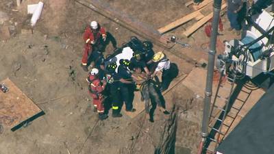 Emergency crews free worker trapped 20 feet down in hole following collapse