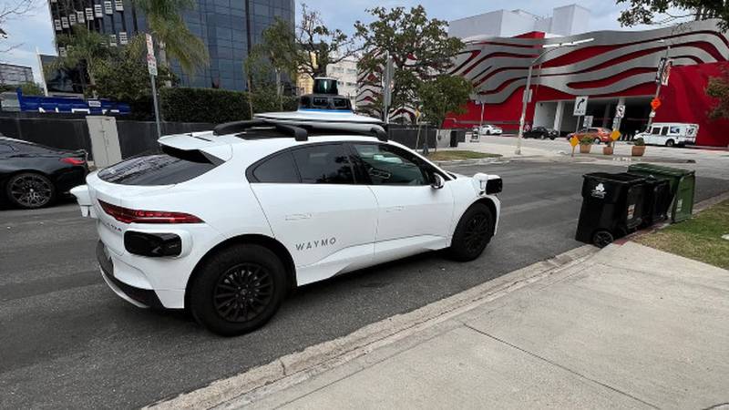 A Jaguar I-Pace autonomous vehicle from Waymo is seen pulling over to collect a passenger, Aug. 1, 2024, in Los Angeles.