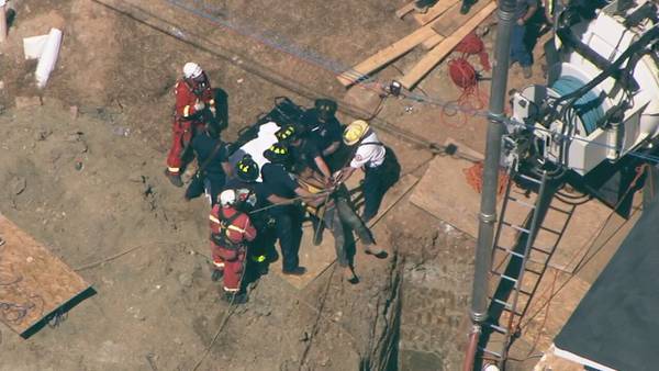 Emergency crews free worker trapped 20 feet down in hole following collapse