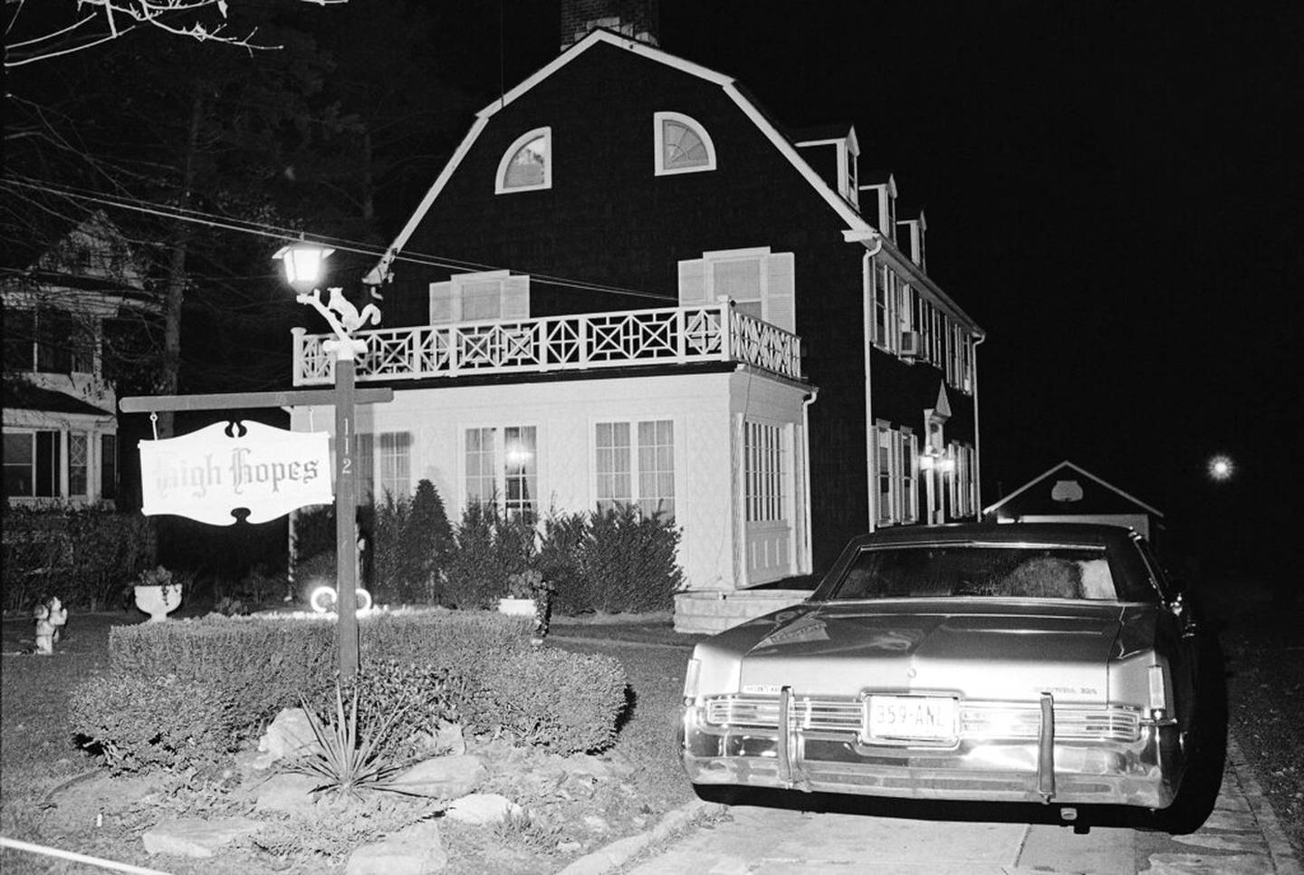 Police and members of the Suffolk County Coroner's Office investigate the murder of six people found shot in Amityville, N.Y., Nov. 14, 1974. The six bodies were from the Ronald DeFeo family and were discovered by another member of the family at early Wednesday evening. (AP Photo/Richard Drew)