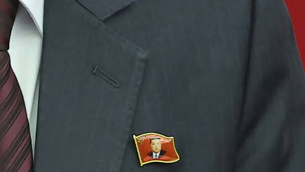 North Koreans are seen wearing Kim Jong Un pins for the first time as his personality cult grows