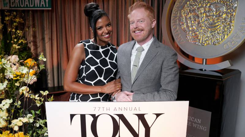 Elise Goldsberry and Jesse Tyler Ferguson stand behind a podium for the Tony Award nominations announcement.
