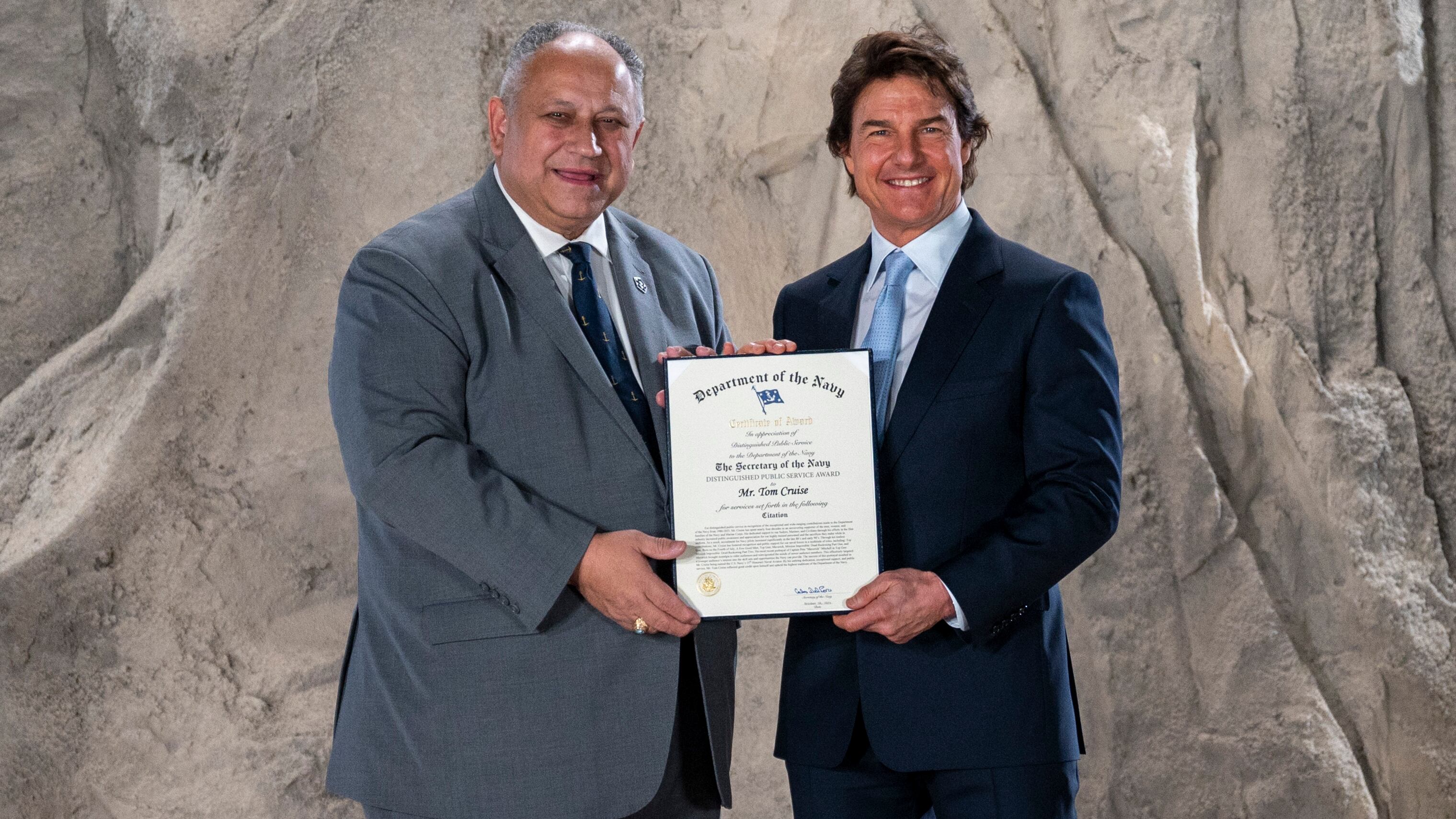 Secretary of the Navy Carlos Del Toro presents Tom Cruise with award.