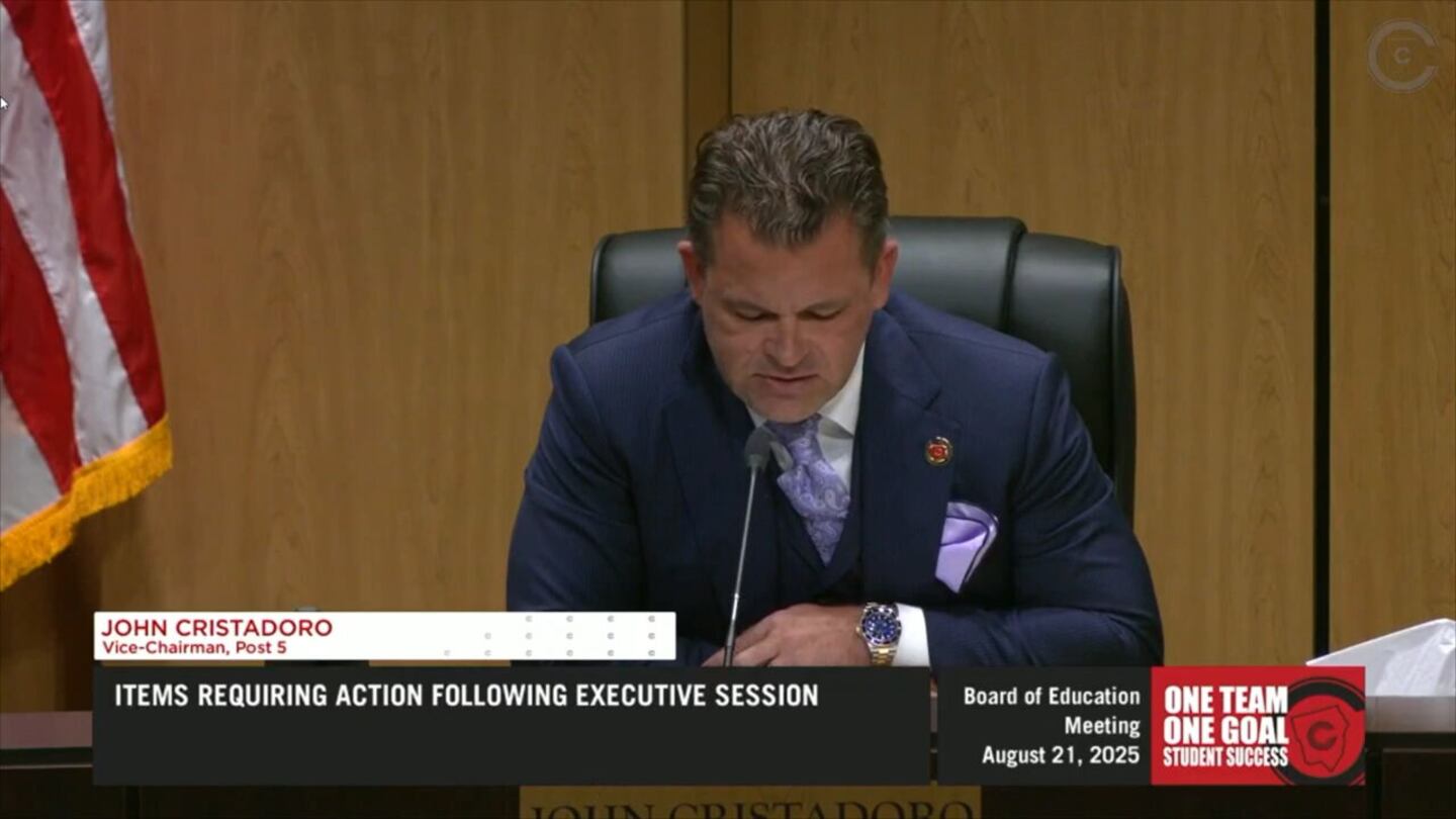 John Cristadoro, vice chair of the Cobb County School Board, is shown looking down, speaking into a microphone.